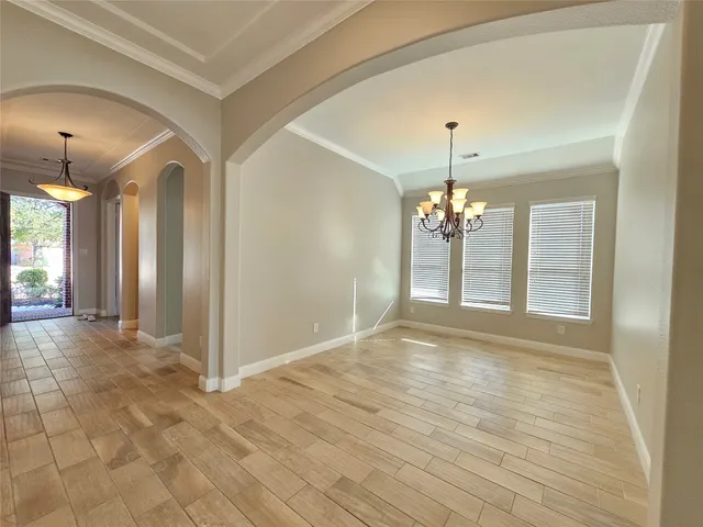 a view of a room with wooden floor and chandelier