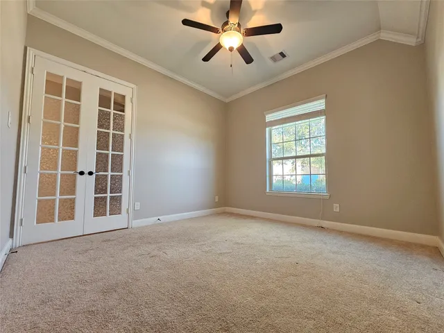 an empty room with windows and ceiling fan