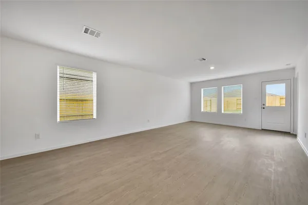a view of an empty room with a window and closet area