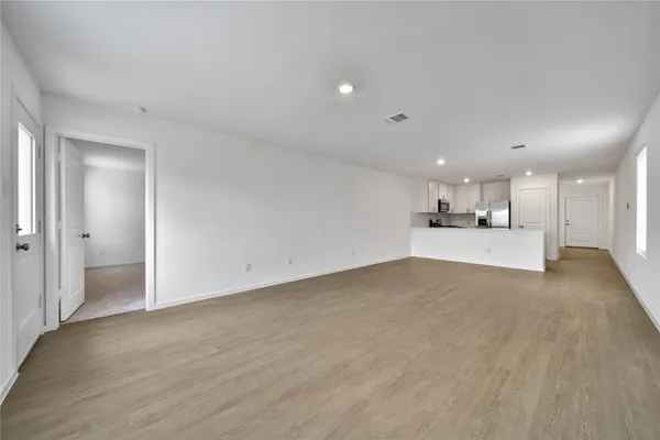 a view of empty room with wooden floor