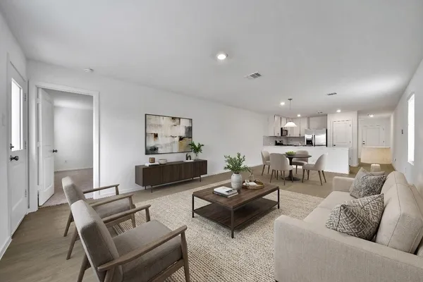 a living room with furniture and a view of kitchen