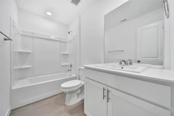 a bathroom with a sink a toilet and a large mirror