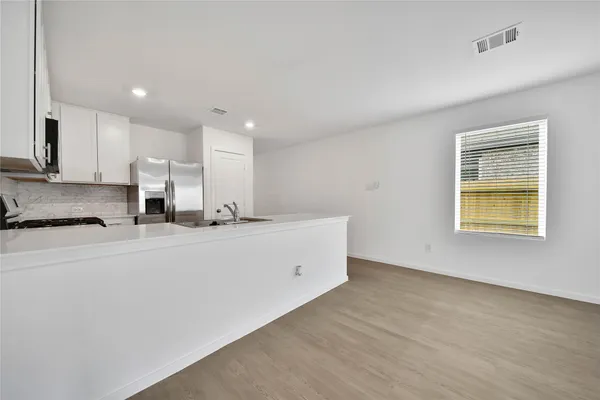 a large white kitchen with a refrigerator a stove a sink and a microwave