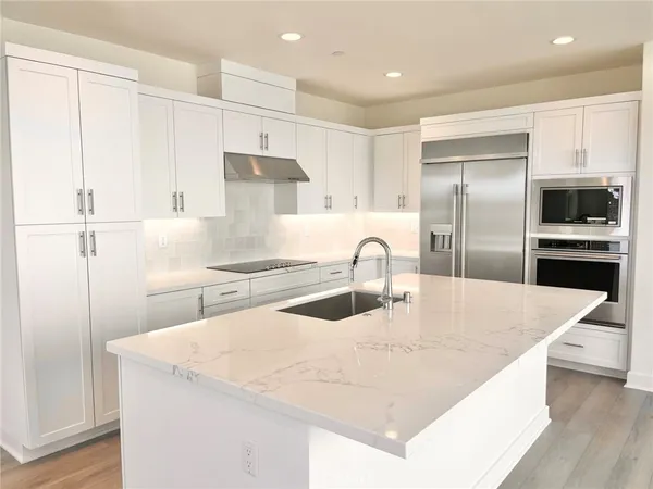 a kitchen with kitchen island a counter top space cabinets and stainless steel appliances