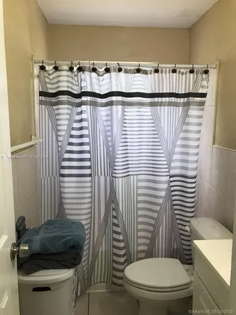 a bathroom with a toilet and a mirror