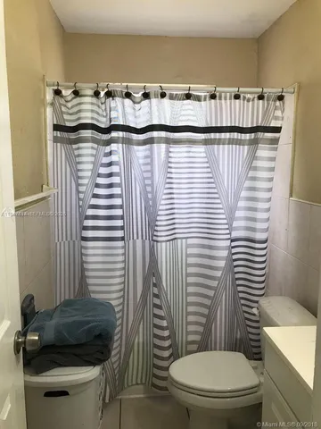 a bathroom with a toilet and a mirror