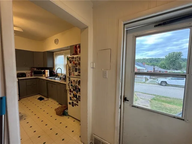 a kitchen with kitchen island a counter top space a large window and stainless steel appliances