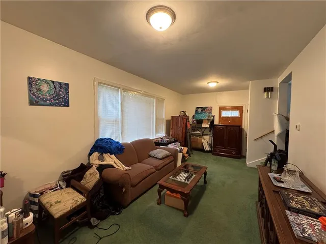 a living room with furniture kitchen view and a window