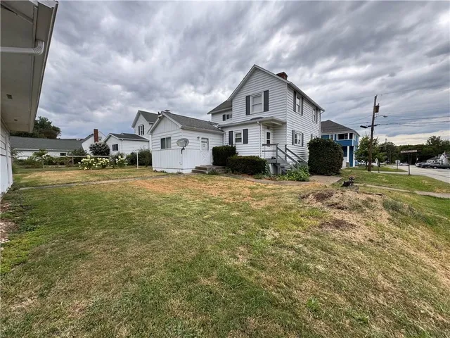 a view of a house with a big yard and large trees