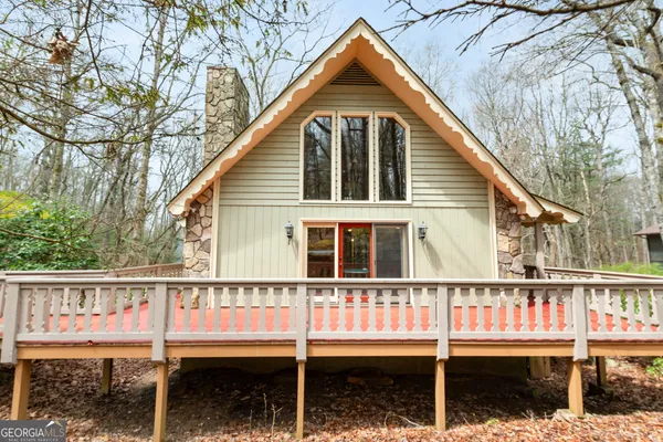 a view of a house with large windows and wooden fence