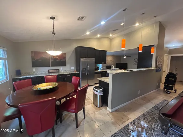 a kitchen with kitchen island a appliances dining table and chairs