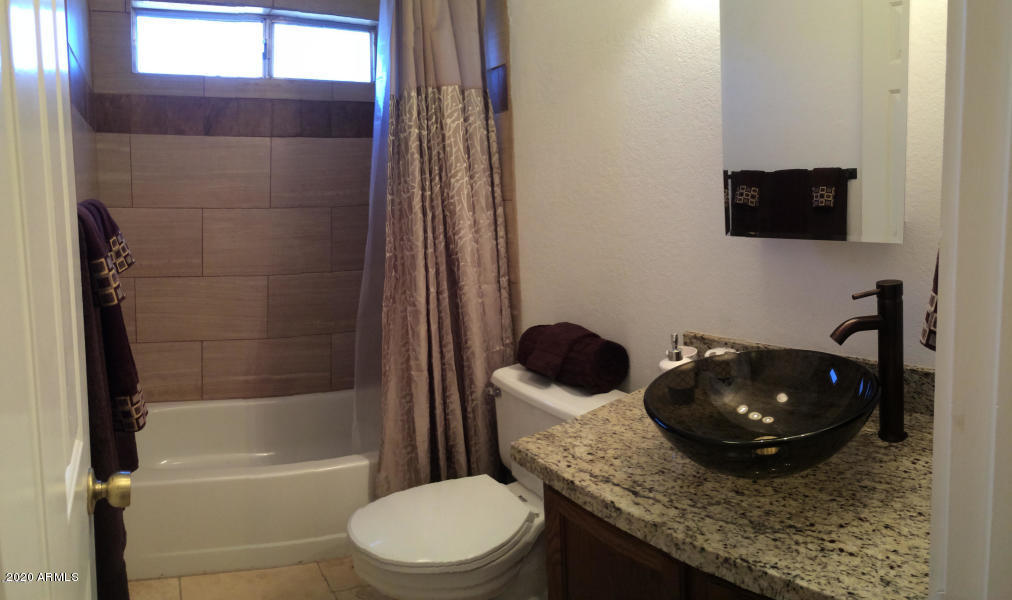 6002 East Beck Lane Scottsdale, AZ 85254 - Photo 21 of 35 a bathroom with a granite countertop toilet sink and mirror