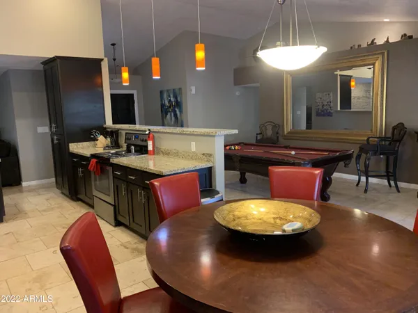 a large kitchen with a table chairs and a chandelier