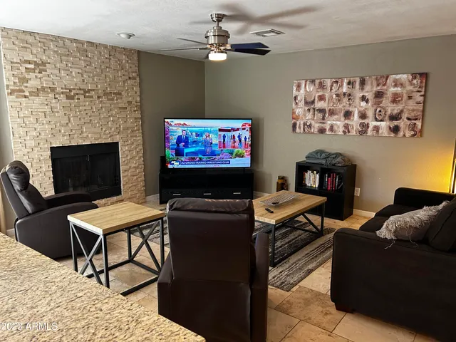 a living room with furniture a flat screen tv and a fireplace