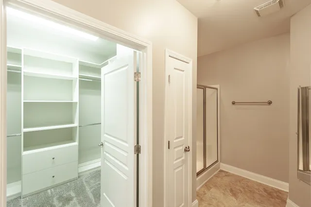 a view of walk in closet with empty racks