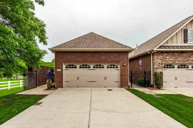 a view of a house with a yard and potted plants