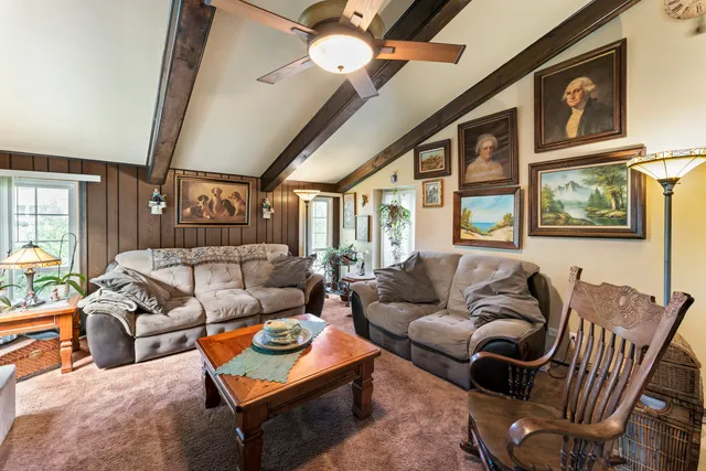 a living room with furniture a ceiling fan and a window
