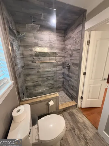a bathroom with a toilet and a shower