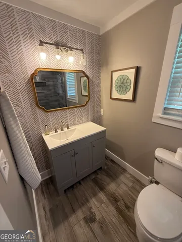 a bathroom with a toilet sink and mirror