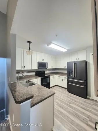 a kitchen with kitchen island granite countertop a sink stove and refrigerator