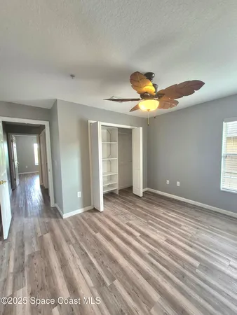 a view of a livingroom with wooden floor and a ceiling fan