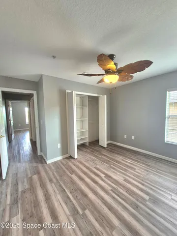 a view of a livingroom with wooden floor and a ceiling fan