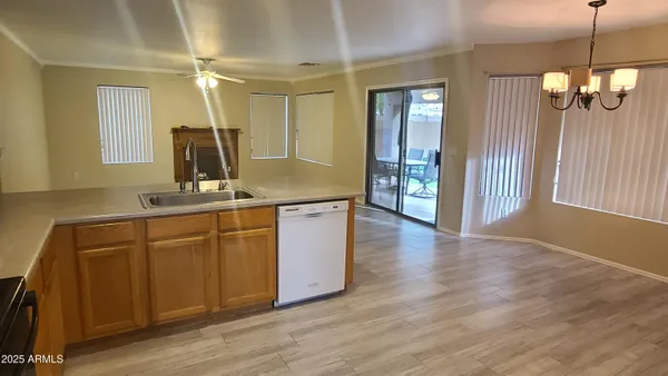 an empty room with wooden floor closet and windows