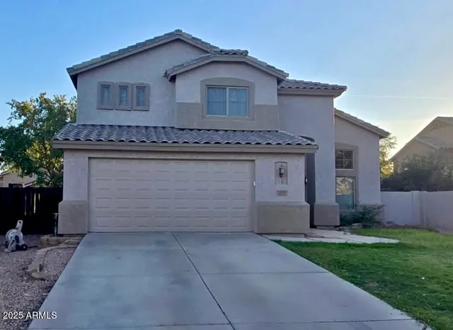 a front view of a house with a garden and trees