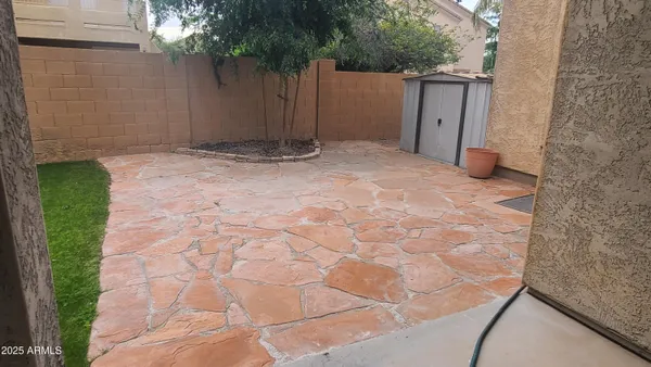 a view of a chair and table in backyard of the house