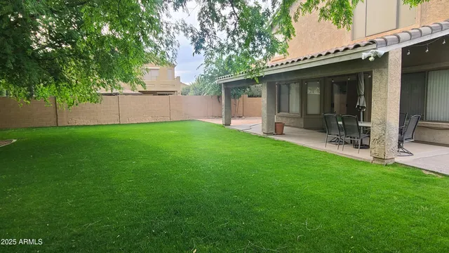 a view of a patio with a table chairs and backyard