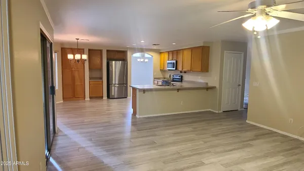 a view of a hallway with wooden floor and a chandelier