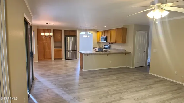 a view of a hallway with wooden floor and a chandelier