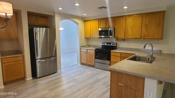 a kitchen with stainless steel appliances granite countertop a stove a sink and a refrigerator