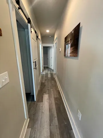 a view of a hallway with wooden floor and staircase