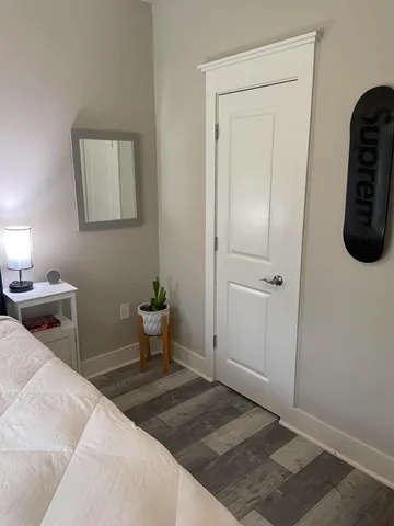 a bedroom with a bed and painting on the wall