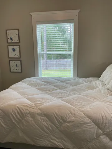 a bedroom with a bed and a large window