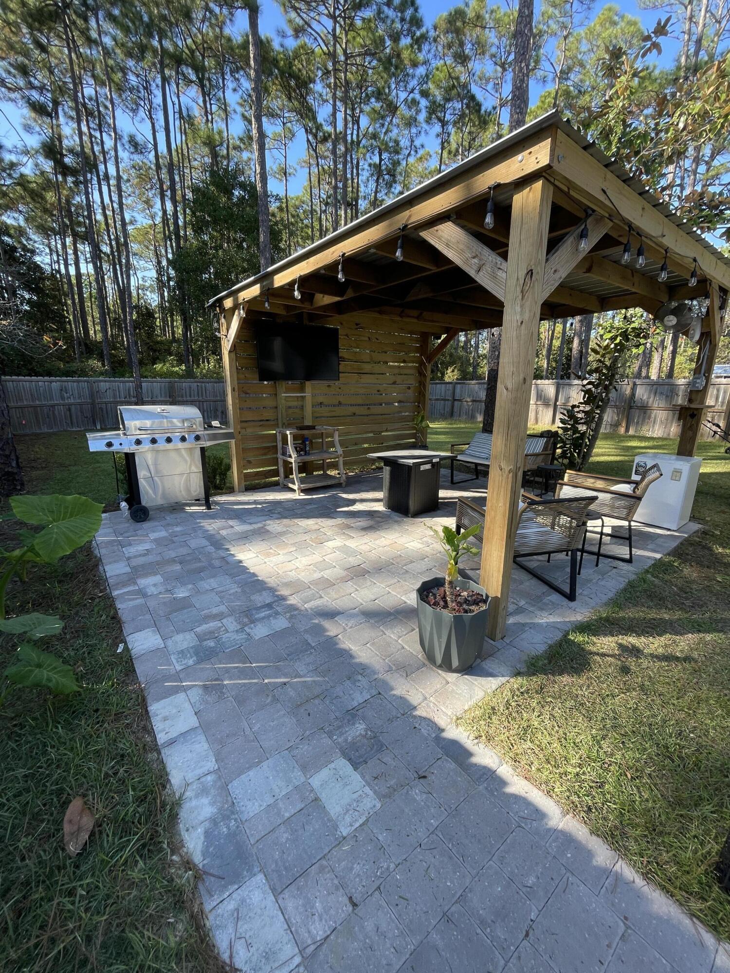 105 1st Street Santa Rosa Beach, FL 32459 - Photo 3 of 35 a view of a backyard with sitting area and slide