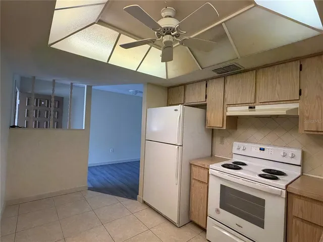 a kitchen with a stove cabinets and white appliances