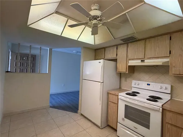 a kitchen with a stove cabinets and white appliances