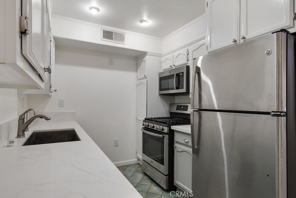 1434 South Point View Street Los Angeles, CA 90035 - Photo 2 of 16 a kitchen with a refrigerator and a sink