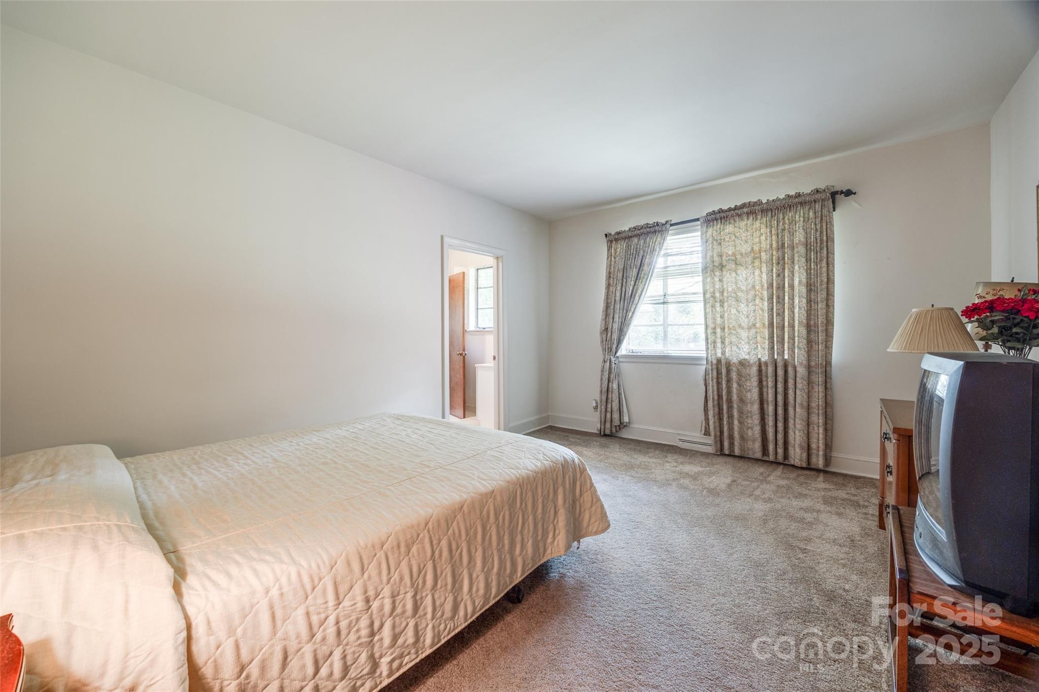 3330 Foxcroft Road Charlotte, NC 28211 - Photo 20 of 39 a bedroom with a bed tv and a window