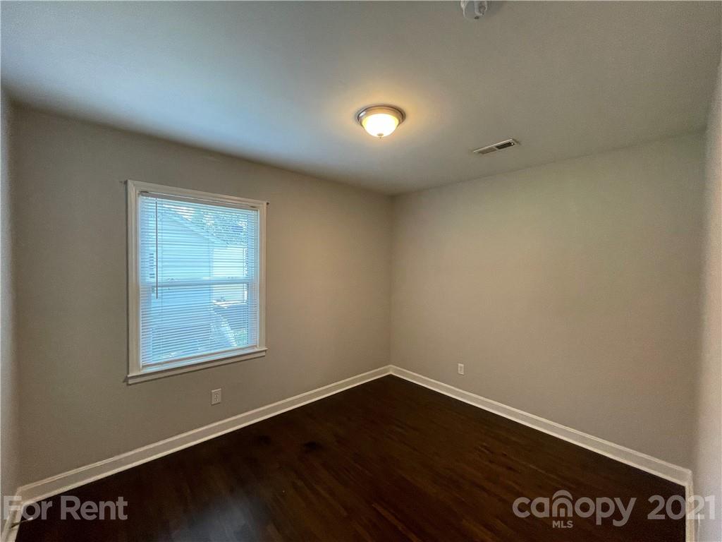 4202 Rutgers Avenue Charlotte, NC 28206 - Photo 6 of 8 an empty room with wooden floor and windows
