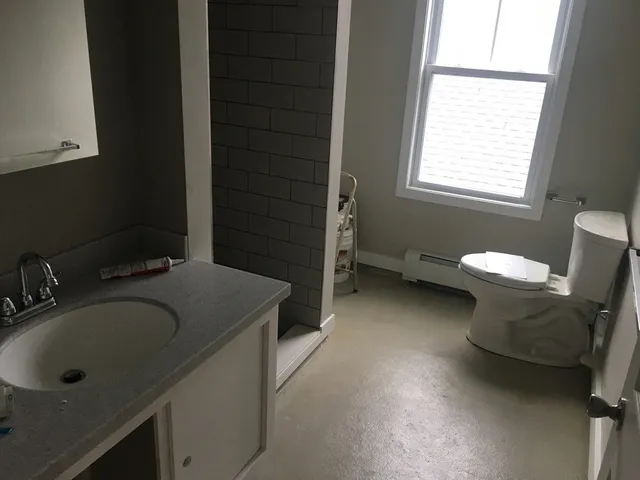 a bathroom with a sink toilet and window