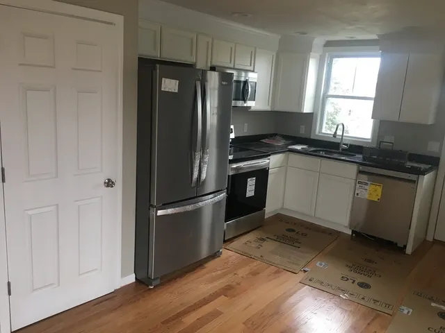a kitchen with granite countertop a refrigerator and a sink