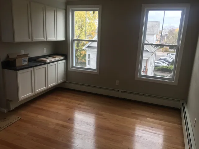 a view of a kitchen with wooden floor and a window