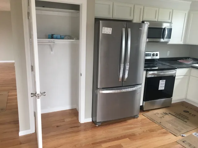 a metallic refrigerator freezer sitting in a kitchen