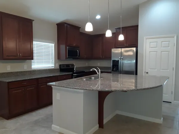 a kitchen with kitchen island granite countertop a sink stainless steel appliances and cabinets