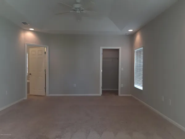 an empty room with windows and closet