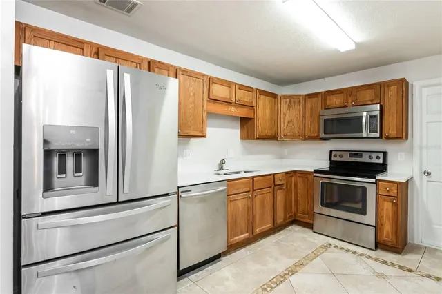 a kitchen with stainless steel appliances granite countertop a refrigerator and a stove top oven