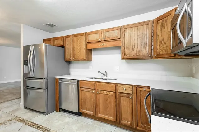 a kitchen with stainless steel appliances granite countertop a refrigerator and a sink